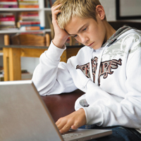 Boy focusing intently on laptop